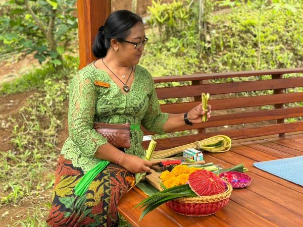 Wanita Bali mengajarkan cara membuat Canang Sari.